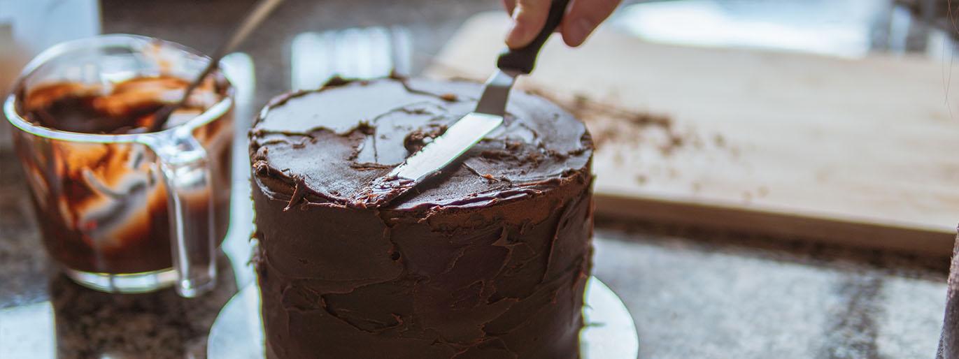 Bolo sendo blindado com ganache liso